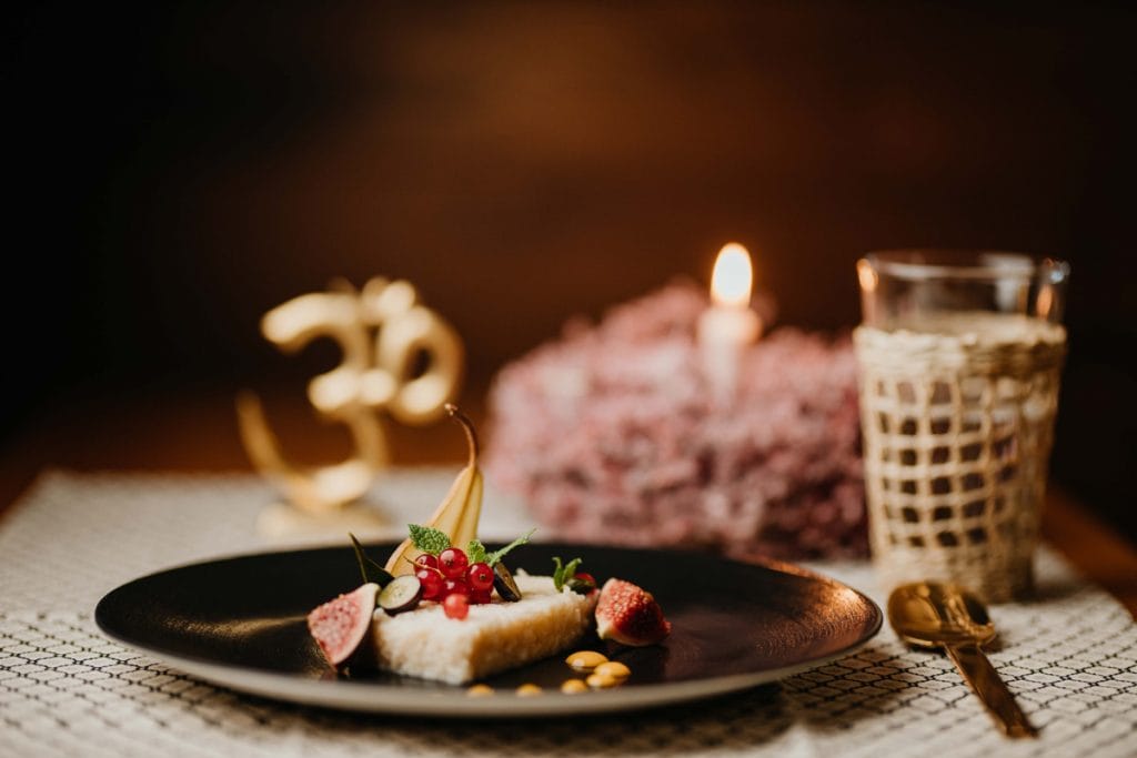 Brot auf dem Teller im Vordergrund, Glas und Kerze im Hintergrund