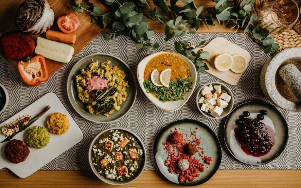 Tisch mit verschiedenen bunt angerichteten Speisen, Ernährung um Ojas aufzubauen