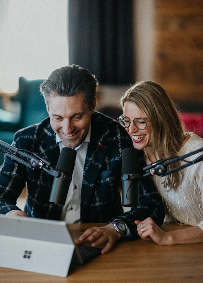 Two people in front of a laptop with a microphone
